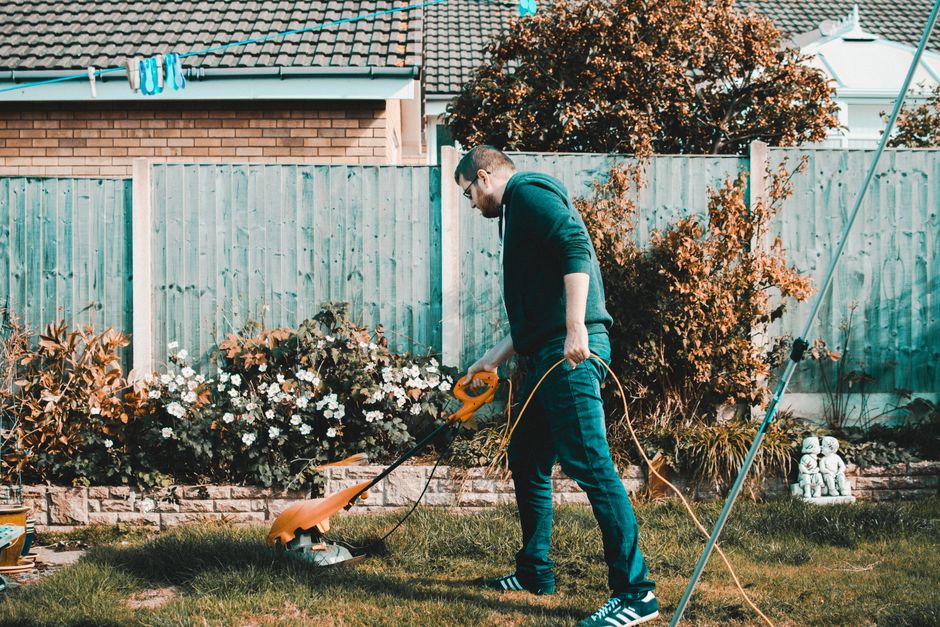 Spring lawn cleanup with grass trimmer removing debris